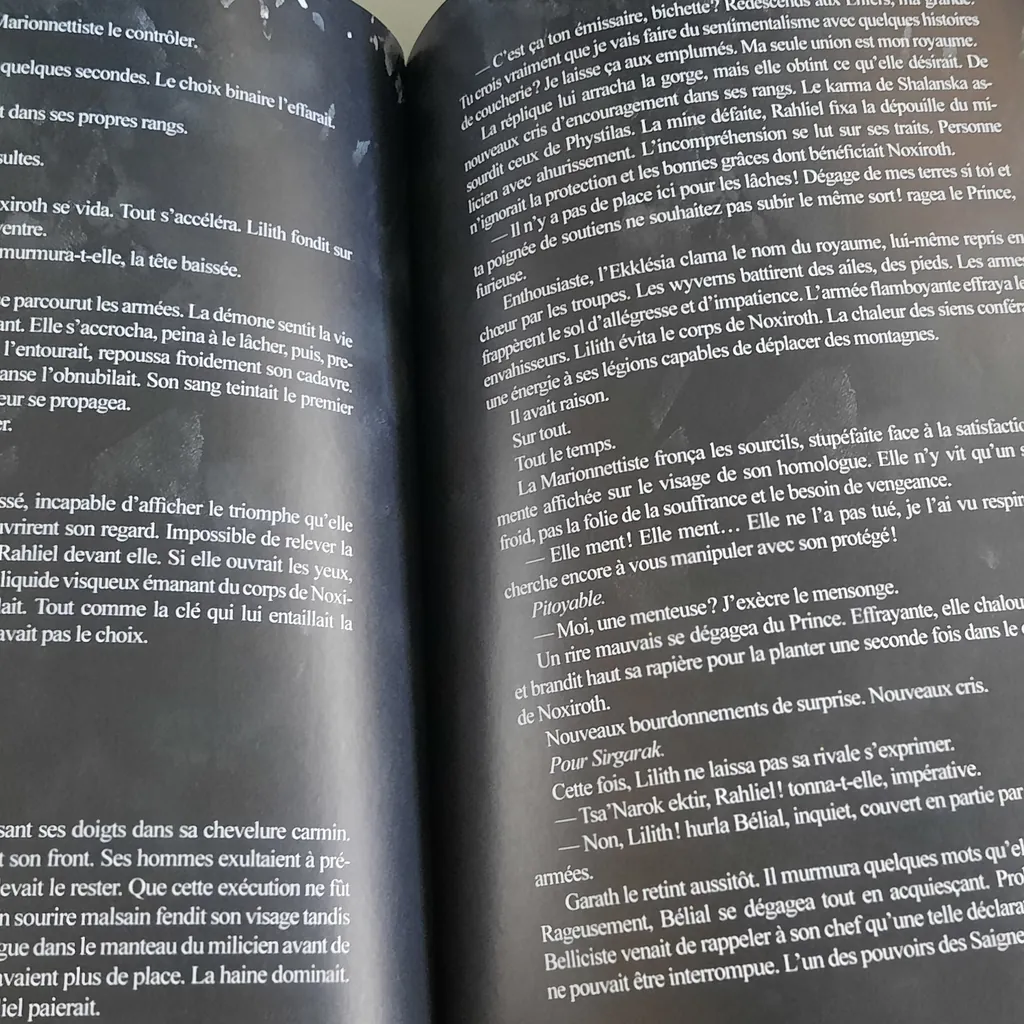 Double page ouverte, texte blanc sur pages entièrement noires